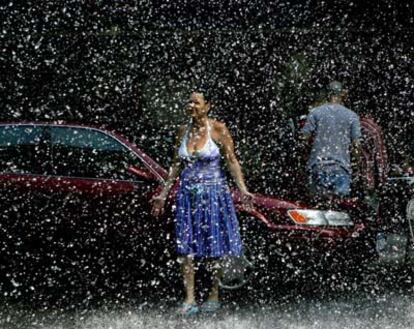 Una mujer se refresca con el agua que sale de una boca de incendios en el Bronx, Nueva York.