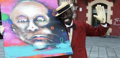 El actor senegalés Mbaye Sène, encargado de interpretar el papel de Chocolat en la 'kalejira' de este jueves, posa con una obra de Cheikhou Ba.