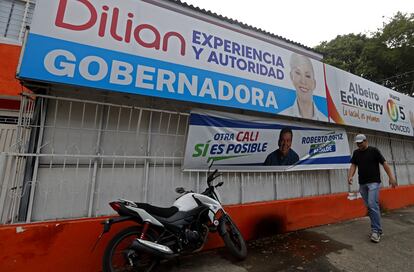 Un transeúnte camina entre propaganda política en Cali (Colombia), el 24 de octubre.