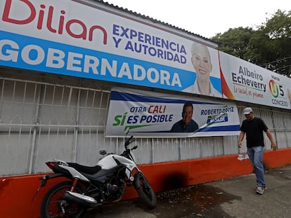 Un transeúnte camina entre propaganda política en Cali (Colombia), el 24 de octubre.