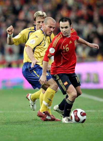 Iniesta conduce el balón presionado por Ljungberg y Edman.