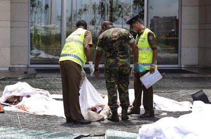 Personal de seguridad inspecciona los restos mortales de varias personas víctimas en el atentado del Hotel Shangri-La en Colombo, este domingo.