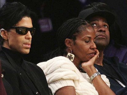 Prince (izquierda) y Denzel Washington, con la esposa de éste, Paulette Pearson, durante el partido.