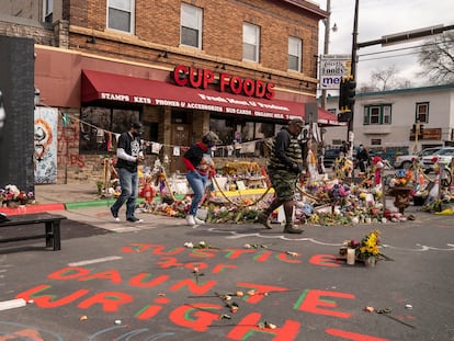 Unos visitantes observan las flores en recuerdo de George Floyd ante la fachada de Cup Foods, en Minneapolis, el 14 de abril.