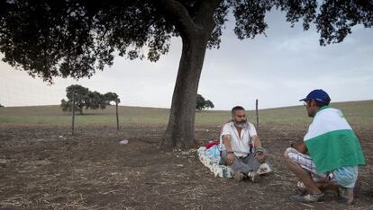 Sánchez Gordillo charla con jornalero tras pernoctar bajo una encina en la finca ocupada de Las Turquillas.