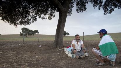 Sánchez Gordillo charla con jornalero tras pernoctar bajo una encina en la finca ocupada de Las Turquillas.