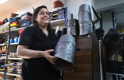 Estrella Caballero sujetando un yelmo de soldado medieval hecho de cuero cromado para emular el metal.