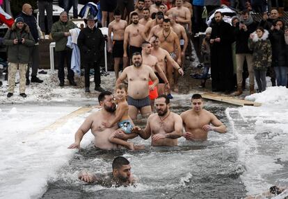 Un grupo de creyentes nadan a través del agua helada del lago Ada Ciganlija durante las celebraciones de la Epifanía, en Belgrado (Serbia).