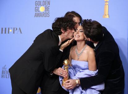 A cantora Lady Gaga é beijada por Anthony Rossomando (esquerda), Andrew Wyatt e Mark Ronson, depois de receber o Globo de Ouro de melhor canção original pelo tema 'Shallow' do filme 'Nasce uma estrela'.