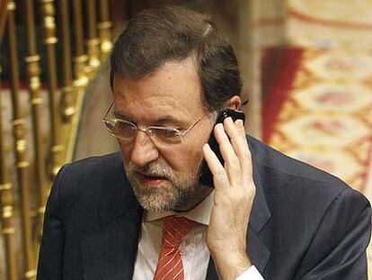 Rajoy habla por teléfono ayer en el Congreso.