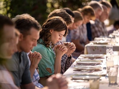 La actriz Daisy Edgar-Jones, en el centro, rezando junto a la familia Lafferty en 'Por mandato del cielo' (Disney+).
