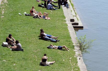 Un grupo de personas toma el sol en la orilla de río Garonne, en Toulouse, sur de Francia.