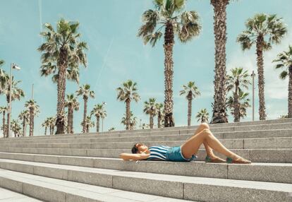 Una chica posa en la playa de la Barceloneta (Barcelona).