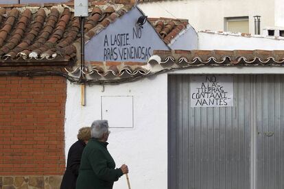 Vecinos de Torrenueva pasan frente a carteles contra la mina.