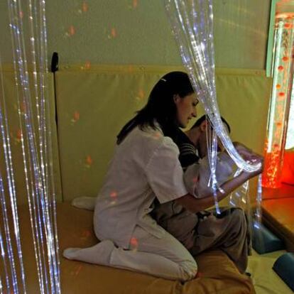 Sala de estimulación sensorial en Mirasierra. La fotografía muestra a una trabajadora atendiendo a una persona con discapacidad severa.