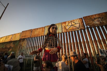La Pequeña Amal, una gigantesca marioneta de 3,5 metros de altura que representa a una niña siria y que es un símbolo de la lucha por los derechos humanos de los refugiados, inició este mes un recorrido por siete ciudades de México. En la imagen, Amal junto al muro fronterizo que separa a las ciudades de Tijuana, en México, y San Diego, en Estados Unidos, el pasado 6 de noviembre.