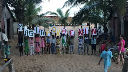 Los niños del centro de Mensajeros por la Paz, posan con un cartel de ‘Magia por Benín’, en Cotonou (Benín).