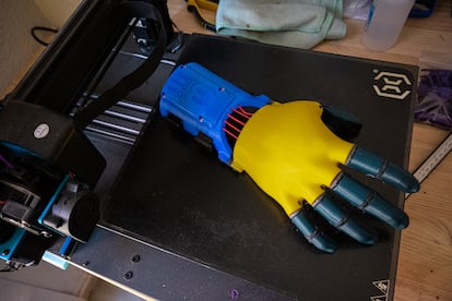 Una de las manos ortopédicas que fabrica José María del Pozo encima de una de sus impresoras 3D.