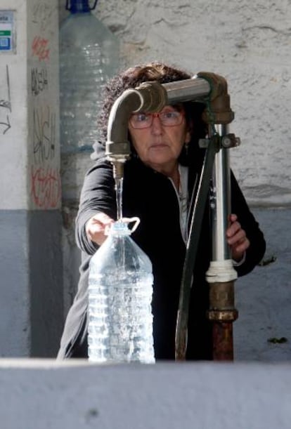 Una vecina de Vigo se abastece de agua potable en una fuente p&uacute;blica.