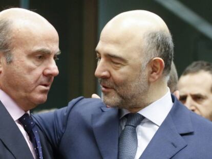 El ministro español de Economía, Luis de Guindos (i) conversa con el comisario europeo de Asuntos Económicos, Pierre Moscovici, durante una reunión de los responsables de Economía y Finanzas de la zona del euro en la sede del Consejo Europeo en Bruselas el 14 de enero de 2016.