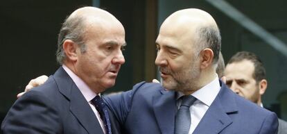 El ministro español de Economía, Luis de Guindos (i) conversa con el comisario europeo de Asuntos Económicos, Pierre Moscovici, durante una reunión de los responsables de Economía y Finanzas de la zona del euro en la sede del Consejo Europeo en Bruselas el 14 de enero de 2016.
