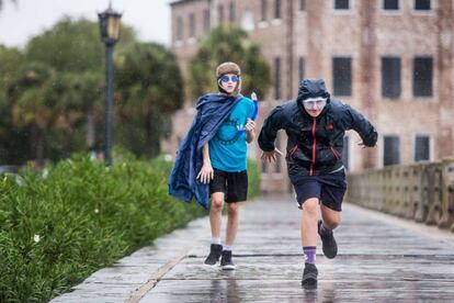 Dos jóvenes corren en Charleston, Carolina del Sur. Las previsiones informan de que este Estado sufrirá el paso del huracán este jueves.