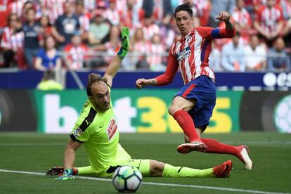 El portero serbio del Eibar Marko Dmitrovic intenta detener un disparo a puerta del delantero español del Atlético de Madrid Fernando Torres.