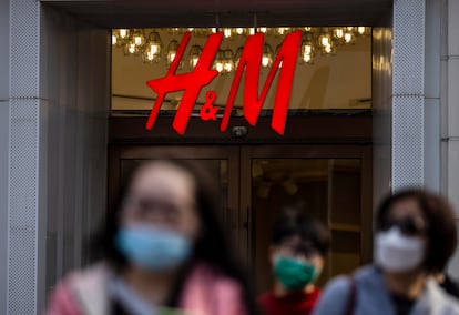 Varias personas pasan por delante de la entrada de una tienda de H&M, este lunes en Shanghái, China.