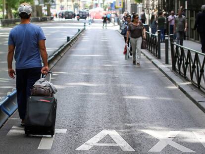 Un turista pasea por el carril Taxi del Paseo del Prado de Madrid durante la huelga de Taxistas.