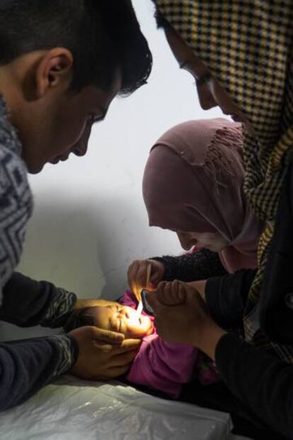Rania, pediatra de Médicos del Mundo, atiende a una niña enferma ayudándose de la luz del móvil.