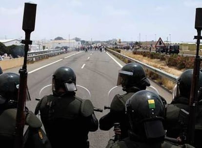 Los antidisturbios vigilan a un grupo de agricultores que corta la A-7 a la altura de El Ejido (Almería).