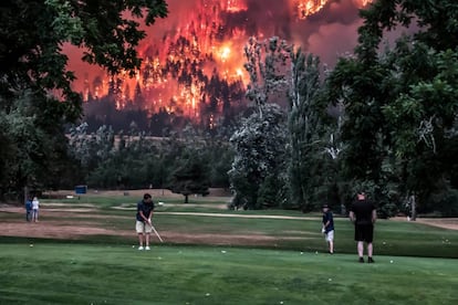 Unos golfistas juegan en el campo de gol Beacon Rock mientras prosigue el incendio forestal de Eagle Creek, en North Bonneville (Estados Unidos).