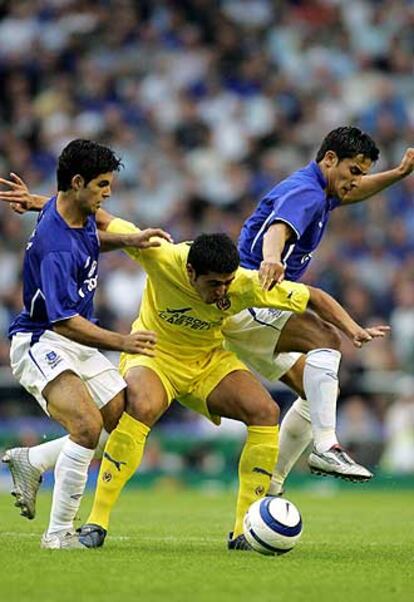 Riquelme protege el balón ante Arteta y Cahill.