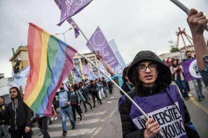 Un hombre enarbola la bandera arcoiris en una manifestación del 1 de mayo.