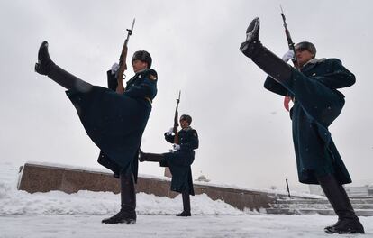 Los guardias de honor kirguisos marchan durante la ceremonia del cambio de guardias en la plaza Ala-Too, durante una nevada en Bishkek.