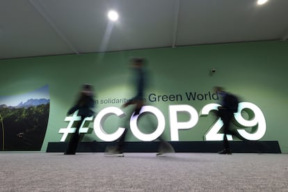 Unos delegados pasan por delante del logo de la COP29, en Bakú, Azerbaiyán.