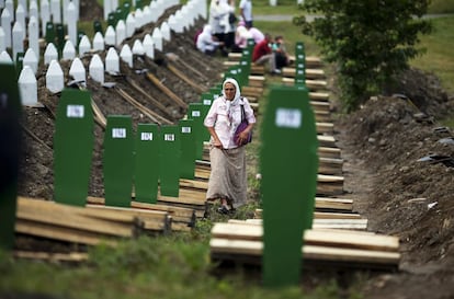 Una mujer camina en medio de varios féretros en el Centro Memorial de Potocari en Srebrenica. Unos 8.000 varones musulmanes fueron asesinados tras la toma de Srebrenica por unidades comandadas por el general Ratko Mladic, el 11 de julio de 1995, pocos meses antes del fin de la guerra, que enfrentó en Bosnia a musulmanes, serbios y croatas.