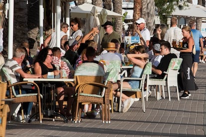 Turistas alemanes disfrutan bebiendo cerveza en la playa de El Arenal de Palma de Mallorca.