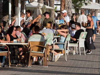 Turistas alemanes disfrutan bebiendo cerveza en la playa de El Arenal de Palma de Mallorca.