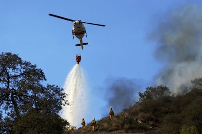 Unos 550 bomberos se han desplazado para tratar de frenar el fuego y han evacuado a todos los residentes del norte de Sierra Madre Avenue y al este de San Gabriel Canyon Road debido a que las llamas se estaban "desplazando con gran agresividad", según explicaron. En la imagen, un helicóptero tira agua sobre los incendios forestales que están quemando las laderas del monte San Gabriel en Glendora, California.