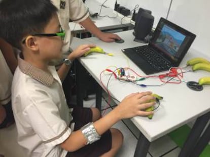 Aluno testa o Pump, o videogame criado por seu colega numa escola pública de Cingapura.