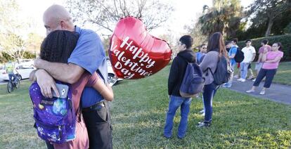 Un familiar abraza a una adolescente tras el tiroteo en el instituto de Parkland.