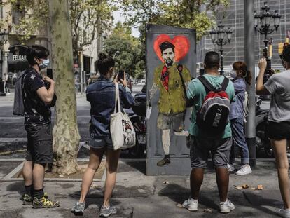 Varios viandantes toman fotografías de una obra del artista TVBoy que representa a Messi, el 29 de agosto en Barcelona.