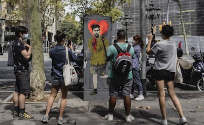 Varios viandantes toman fotografías de una obra del artista TVBoy que representa a Messi, el 29 de agosto en Barcelona.