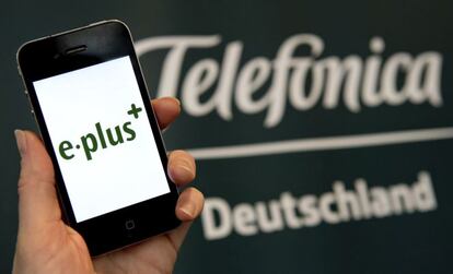 Un m&oacute;vil de E-Plus junto al logo de Telef&oacute;nica Deutschland.