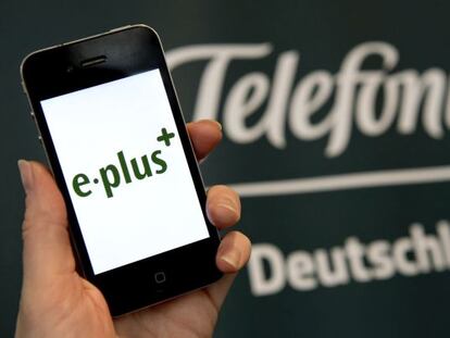 Un m&oacute;vil de E-Plus junto al logo de Telef&oacute;nica Deutschland.