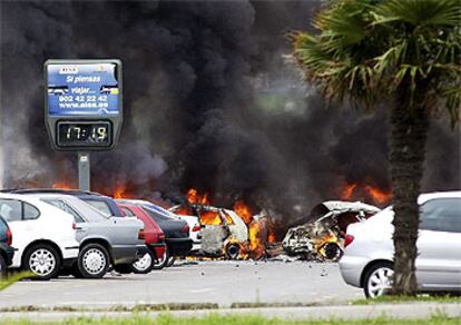 Una columna de humo sale de los restos del coche bomba en el aparcamiento del aeropuerto de Santander