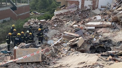 Los bomberos retiran manualmente los escombros, mientras la máquina retroexcavadora allana terreno para que pueda acceder la grúa de gran tonelaje que retirará el forjado más pesado, este jueves.