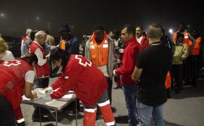 Voluntarios de Cruz Roja atienden a algunas de las 54 personas que han llegado al puerto de Motril.