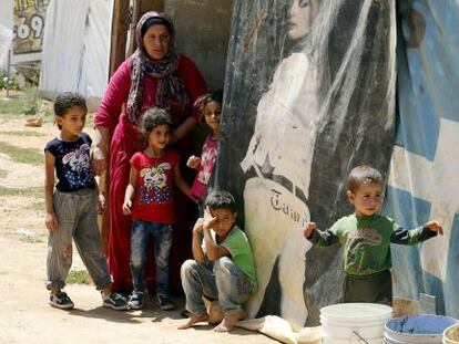 Una mujer y varios niños sirios del campo de refugiados libanés de Saadnayel.